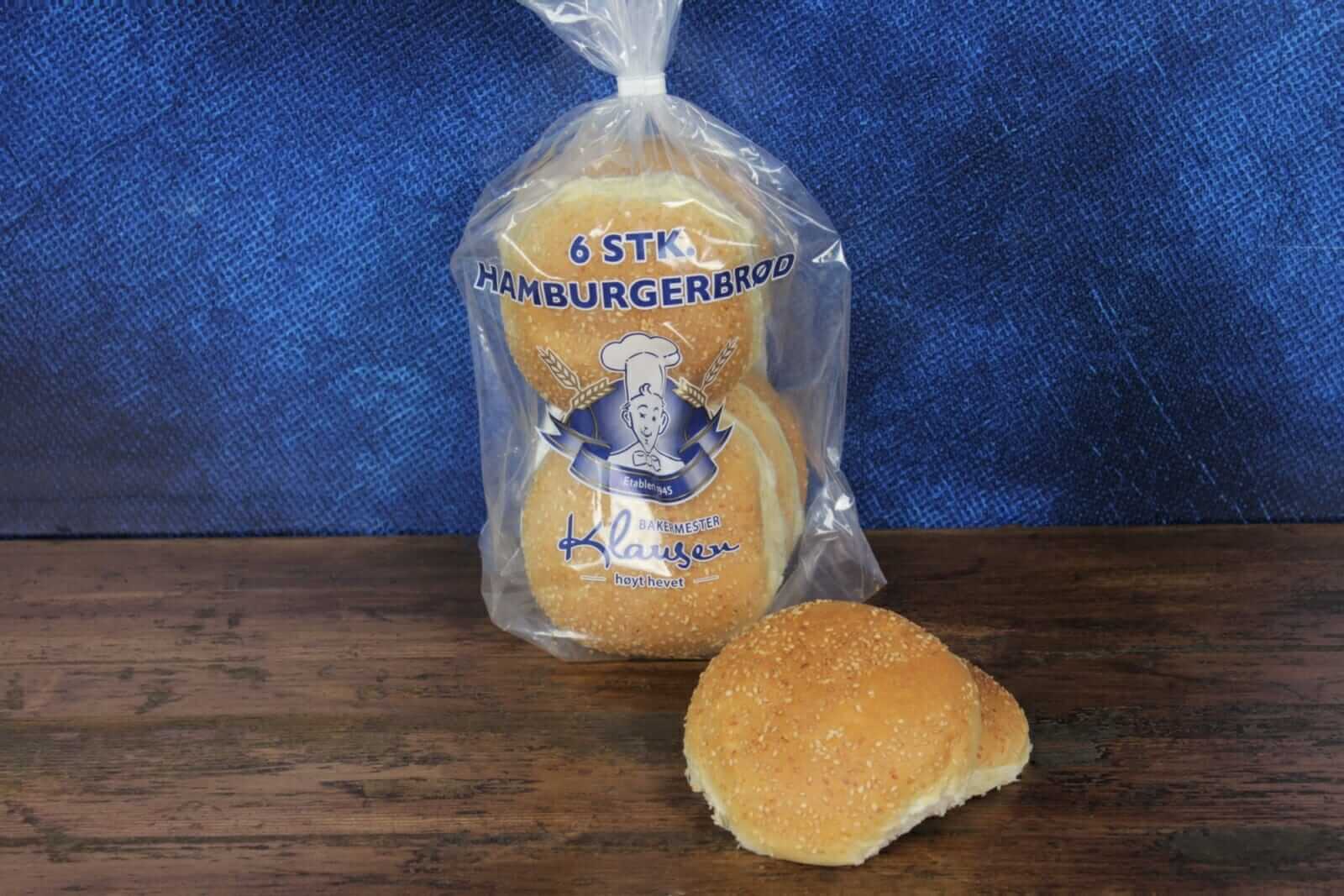 Pose med seks hamburgerbrød med valmuefrø på toppen fra Baker Klausen på et trebord