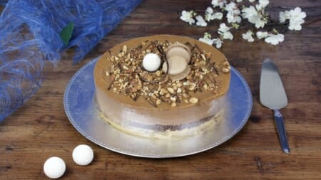 Karamellfristelsekake med melkesjokolademousse og karamellganache, pyntet med makroner og nøtter